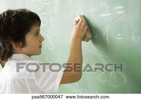 Stock Photo - Little boy erasing classroom blackboard. Fotosearch