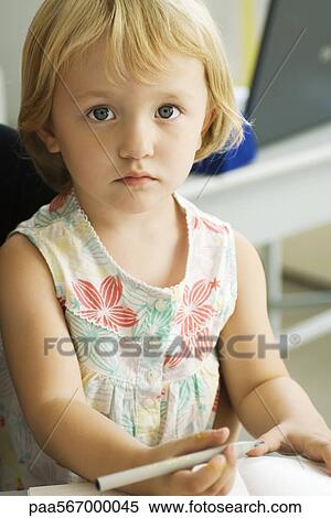 Little girl holding pen, looking at camera View Large Photo Image Stock Photography - Little girl holding pen, looking at camera. Fotosearch