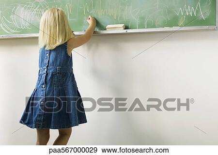 Little girl scribbling with chalk on blackboard View Large Photo Image Stock Photo - Little girl scribbling with chalk on blackboard. Fotosearch