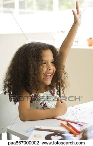 Little girl sitting at school desk, raising hand enthusiastically View Large Photo Image Stock Image - Little girl sitting at school desk, raising hand enthusiastically. Fotosearch