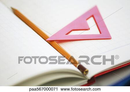 Pencil and triangle resting on notebook View Large Photo Image Stock Image - Pencil and triangle resting on notebook. Fotosearch