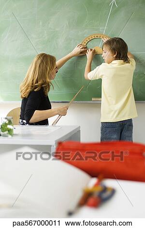 Teacher showing elementary student how to draw angle using protractor View Large Photo Image Stock Image - Teacher showing elementary student how to draw angle using protractor. Fotosearch