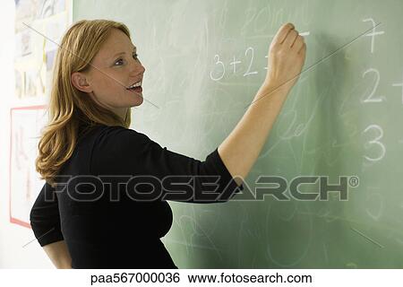 Teacher writing on blackboard View Large Photo Image Stock Photograph - Teacher writing on blackboard. Fotosearch