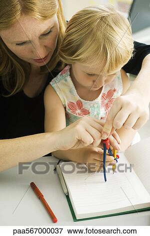 Woman helping little girl draw with compass View Large Photo Image Stock Photo - Woman helping little girl draw with compass. Fotosearch