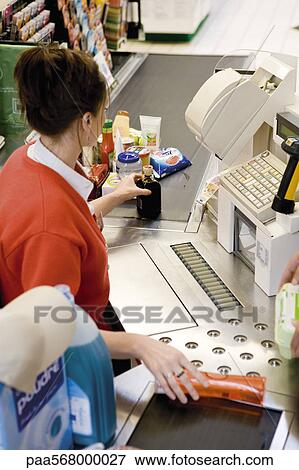 Cashier scanning purchases at checkout counter View Large Photo Image Stock Photo - Cashier scanning purchases at checkout counter. Fotosearch