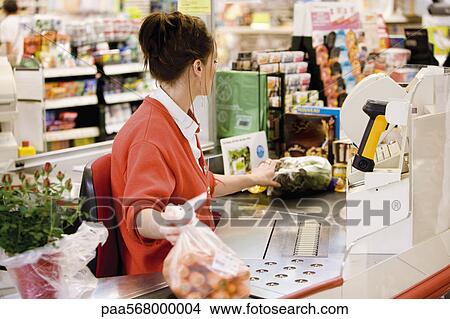 Cashier totaling grocery purchases View Large Photo Image Picture - Cashier totaling grocery purchases. Fotosearch