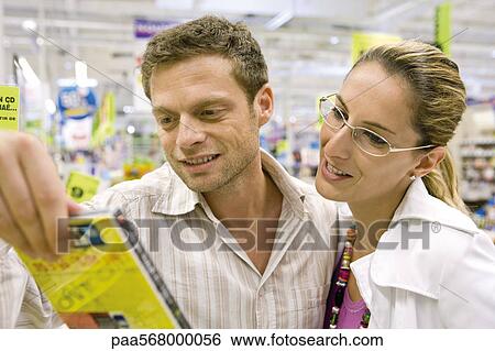 Stock Photograph - Couple looking at DVD together in store. Fotosearch