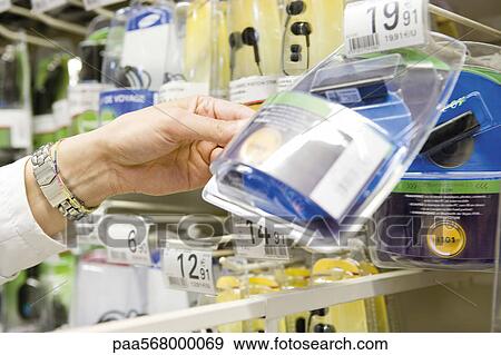 Selecting wireless earpiece from store display View Large Photo Image Stock Photo - Selecting wireless earpiece from store display. Fotosearch