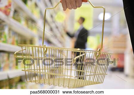 Shopper carrying small shopping basket, cropped View Large Photo Image Stock Image - Shopper carrying small shopping basket, cropped. Fotosearch