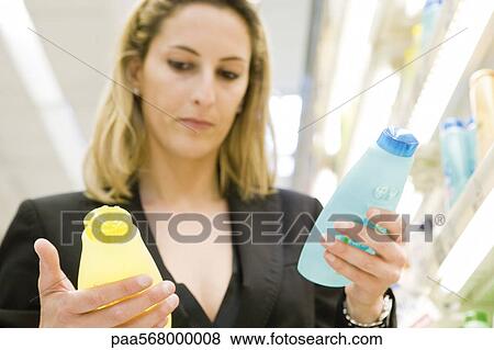 Stock Photo - Woman comparing body care products. Fotosearch