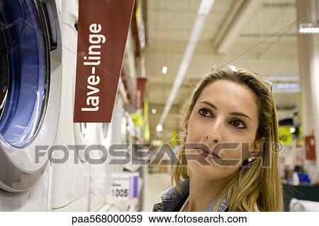 Woman looking at washing machine on display in department store View Large Photo Image Stock Photo - Woman looking at washing machine on display in department store. Fotosearch