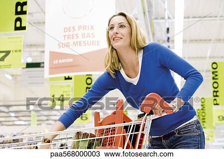 Woman with shopping cart in supermarket View Large Photo Image Stock Image - Woman with shopping cart in supermarket. Fotosearch