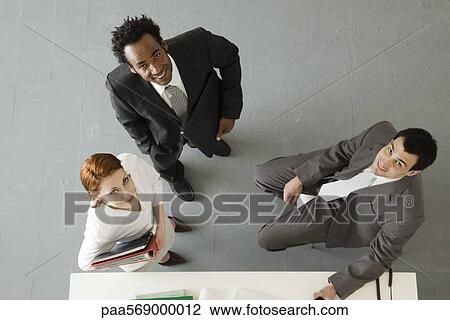 Business colleagues in office, all smiling up at camera View Large Photo Image Stock Image - Business colleagues in office, all smiling up at camera. Fotosearch