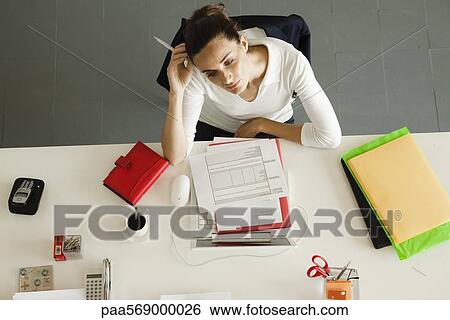Stock Photograph - Businesswoman daydreaming at desk. Fotosearch