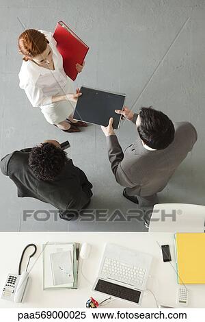 Businesswoman handing notebook to colleague View Large Photo Image Stock Photography - Businesswoman handing notebook to colleague. Fotosearch