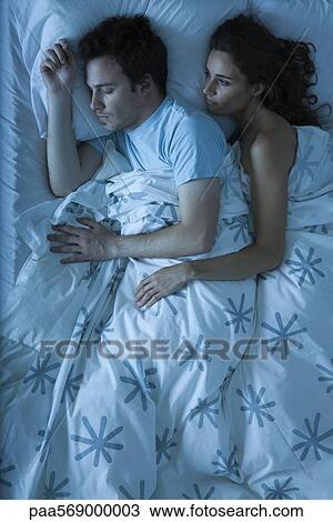 Couple together in bed, woman embracing man, watching him sleep View Large Photo Image Stock Image - Couple together in bed, woman embracing man, watching him sleep. Fotosearch