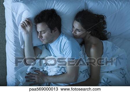 Couple together in bed, woman embracing man, watching him sleep View Large Photo Image Stock Image - Couple together in bed, woman embracing man, watching him sleep. Fotosearch