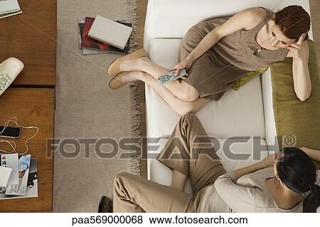 Stock Photo - Friends hanging out watching TV together. Fotosearch