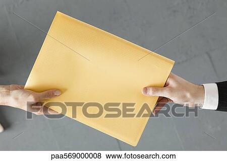 Stock Photo - Handing colleague large brown envelope. Fotosearch