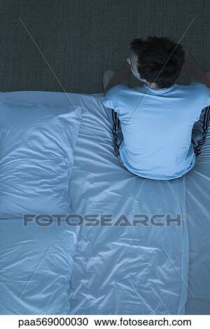 Man sitting on bed unable to sleep View Large Photo Image Stock Image - Man sitting on bed unable to sleep. Fotosearch