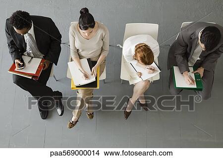 Picture - Professionals taking notes during meeting. Fotosearch