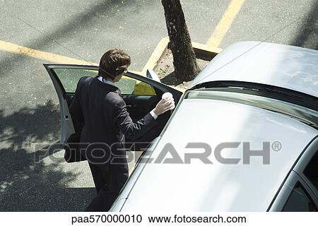 Stock Image - Businessman getting into car. Fotosearch