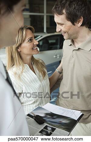 Couple at car dealership preparing to buy new car View Large Photo Image Stock Photo - Couple at car dealership preparing to buy new car. Fotosearch