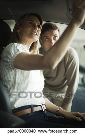 Couple checking out new car interior in dealership showroom View Large Photo Image Stock Image - Couple checking out new car interior in dealership showroom. Fotosearch