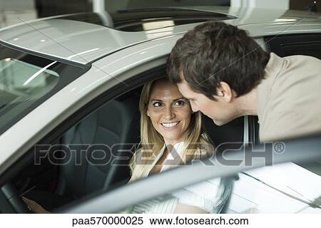 Couple checking out new cars in dealership showroom View Large Photo Image Stock Photography - Couple checking out new cars in dealership showroom. Fotosearch