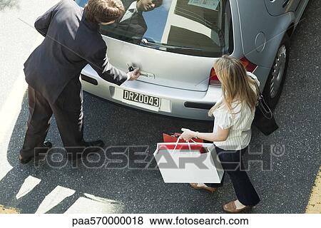 Couple opening car hatchback to stow shopping bags View Large Photo Image Stock Photo - Couple opening car hatchback to stow shopping bags. Fotosearch