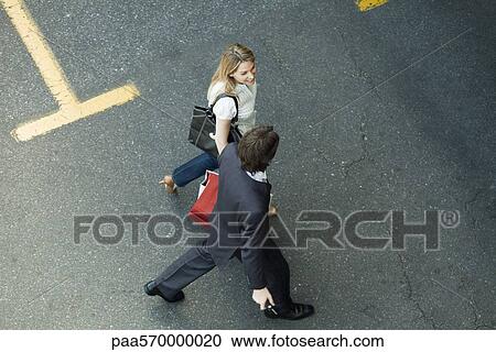 Couple walking together across parking lot, woman carrying shopping bags View Large Photo Image Stock Image - Couple walking together across parking lot, woman carrying shopping bags. Fotosearch