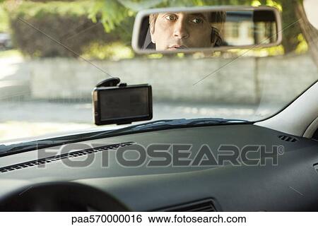 Driver checking rear-view mirror View Large Photo Image Stock Photograph - Driver checking rear-view mirror. Fotosearch