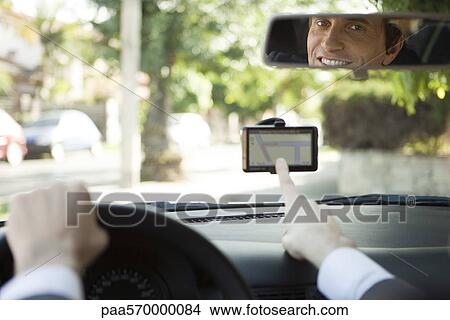 Driver using GPS for navigation assistance View Large Photo Image Picture - Driver using GPS for navigation assistance. Fotosearch