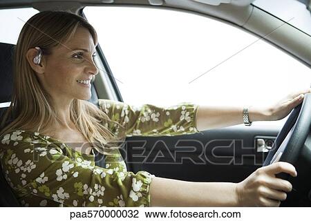 Driving while using hands free bluetooth earpiece View Large Photo Image Stock Image - Driving while using hands free bluetooth earpiece. Fotosearch