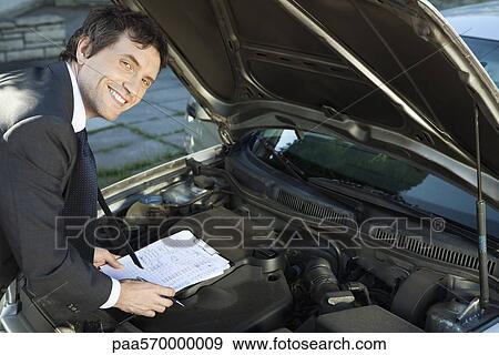 Inspecting car engine View Large Photo Image Stock Photo - Inspecting car engine. Fotosearch
