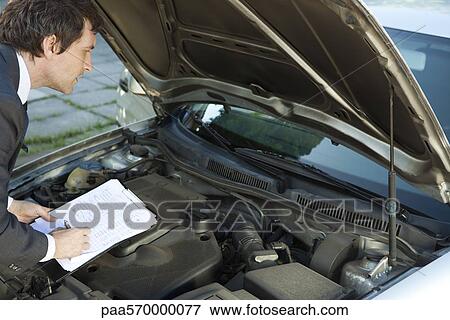 Inspecting car engine View Large Photo Image Stock Photo - Inspecting car engine. Fotosearch