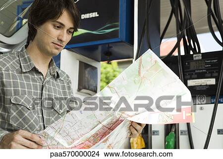 Man checking map at gas station View Large Photo Image Picture - Man checking map at gas station. Fotosearch