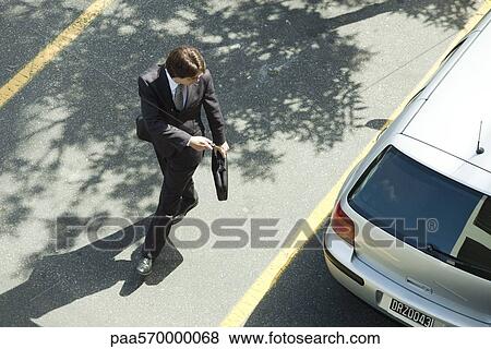 Man locking car doors using key remote as he walks away View Large Photo Image Stock Photo - Man locking car doors using key remote as he walks away. Fotosearch