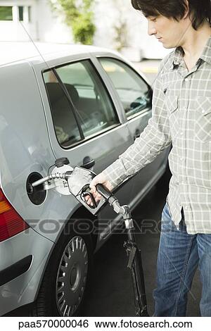 Stock Photograph - Man refueling car at gas station. Fotosearch