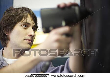 Stock Photo - Mechanic changing car tire. Fotosearch