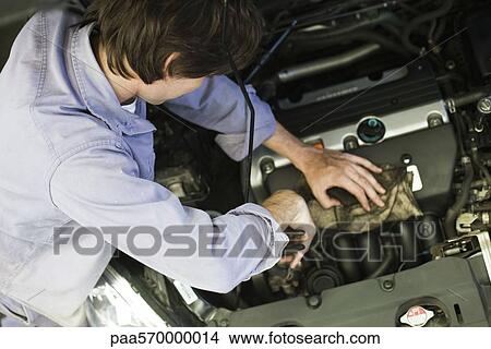 Mechanic repairing car engine View Large Photo Image Picture - Mechanic repairing car engine. Fotosearch