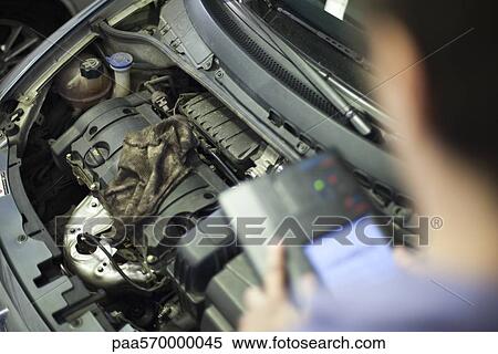 Mechanic working on car engine View Large Photo Image Stock Photography - Mechanic working on car engine. Fotosearch