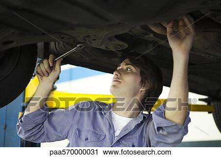 Mechanic working on underside of car elevated on hydraulic lift View Large Photo Image Stock Image - Mechanic working on underside of car elevated on hydraulic lift. Fotosearch