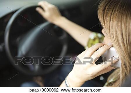 Using cell phone while driving View Large Photo Image Stock Image - Using cell phone while driving. Fotosearch