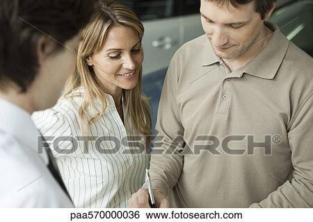 Woman watching as husband signs document View Large Photo Image Stock Photograph - Woman watching as husband signs document. Fotosearch