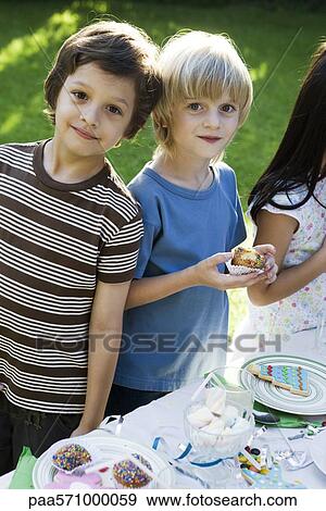 Boys eating cupcakes View Large Photo Image Stock Photo - Boys eating cupcakes. Fotosearch