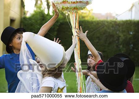 Stock Photography - Children reaching to pull streamers attached to pull string pinata. Fotosearch