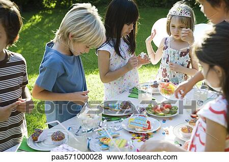 Children selecting sweets from table at outdoor birthday party View Large Photo Image Stock Photo - Children selecting sweets from table at outdoor birthday party. Fotosearch