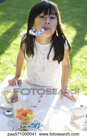 Girl at party enthusiastically blowing party horn blower View Large Photo Image Stock Image - Girl at party enthusiastically blowing party horn blower. Fotosearch