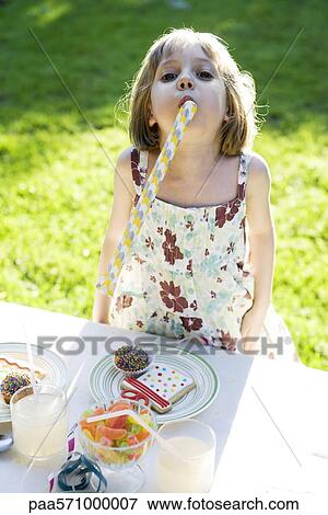 Girl at party enthusiastically blowing party horn blower View Large Photo Image Stock Photo - Girl at party enthusiastically blowing party horn blower. Fotosearch